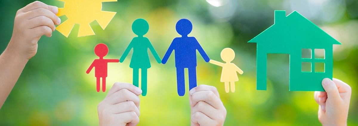 Vier Kinderhände halten bunte Familie aus Papier in die Luft vor unscharfen grünen Bäumen - Immobiliensuche -