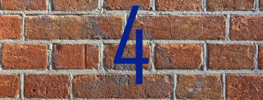 Blaue Zahl Vier vor roter Backsteinmauer - Immobilienfinanzierung