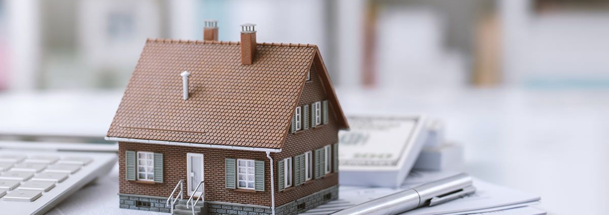 Ein Häuschen steht auf einem Stapel Papiere - Lastenfreiheit