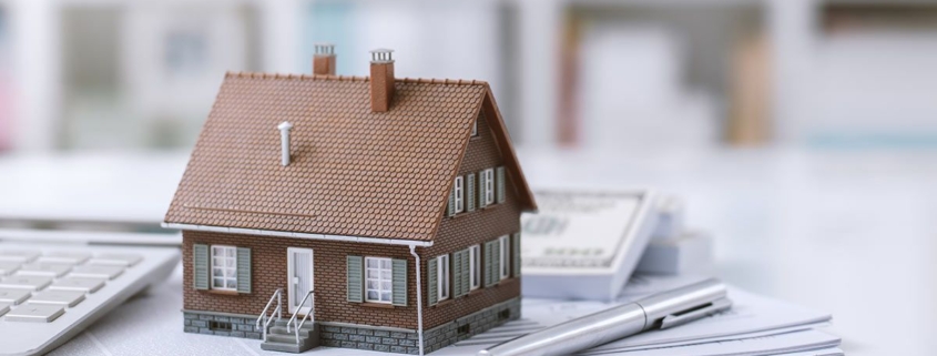 Ein Häuschen steht auf einem Stapel Papiere - Lastenfreiheit