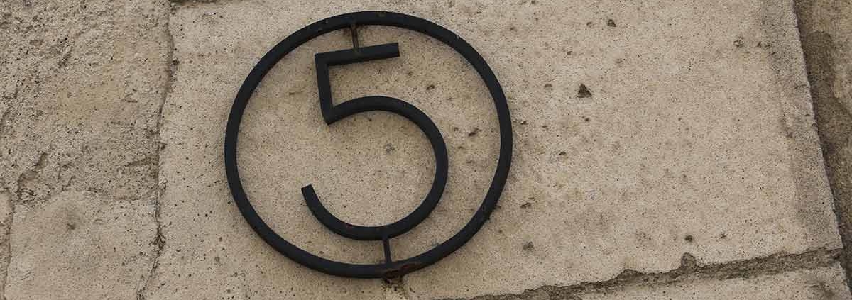 Eine eiserne fünf in einem Ring an einer Hauswand | Erneuerbare Energien