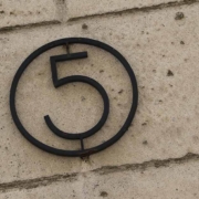 Eine eiserne fünf in einem Ring an einer Hauswand | Erneuerbare Energien