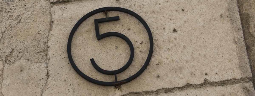 Eine eiserne fünf in einem Ring an einer Hauswand | Erneuerbare Energien