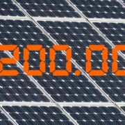 Die Zahl 2,2 Millionen in Orange vor einem Hintergrund aus Solarpaneelen - Photovoltaik