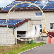 Eine Hand mit Lupe vor einem Haus mit Garage - Suchauftrag