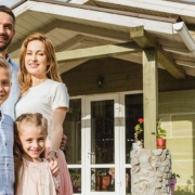 Glückliche Familie vor Effizienzhaus 40, das vom Staat gefördert wurde.