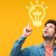 Einem Immobiliensuchenden mit erhobenem rechten Zeigefinger vor einem gelben Hintergrund geht ein Licht auf, dargestellt als Grafik einer Glühbirne zwischen seinem Kopf und dem erhobenen Zeigefinger | Immobilie suchen und finden