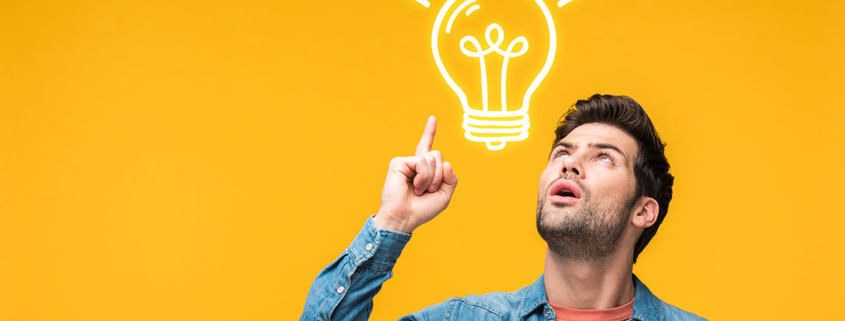 Einem Immobiliensuchenden mit erhobenem rechten Zeigefinger vor einem gelben Hintergrund geht ein Licht auf, dargestellt als Grafik einer Glühbirne zwischen seinem Kopf und dem erhobenen Zeigefinger | Immobilie suchen und finden