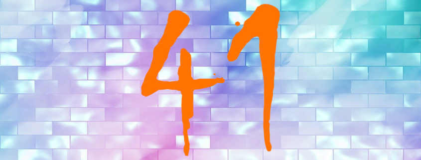 Auf einer pastellfarbenen bunten Wand steht eine orangefarbene 41 | Mietmarkt