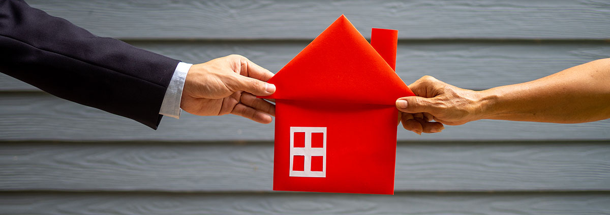 Mann und Frau ziehen an einem roten Haus aus Stoff | Scheidung