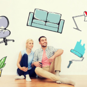 Junges Paar sitzt in leerer Wohnung und träumt von gemeinsamer Wohnung samt Renovierung und dem Kauf von Möbeln, Lampen und Grünpflanzen