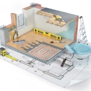 Querschnitt eines Hauses ohne Dach, das auf einem Grundrissplan steht. In und neben dem Haus Utensilien, die man für die Renovierung braucht. | Sanieren vor dem Verkauf