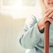 Growing old is inevitable, but growing up is optional. elderly woman resting her hands on her walking stick while relaxing at home; Wohnen im Alter