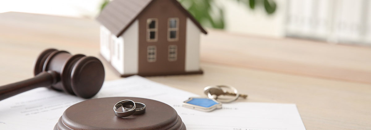 Richterhammer, mit Eheringen und Papieren auf einem Tisch, dahinter ein Modellhaus und Schlüssel; Teilungsversteigerung