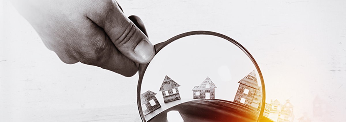 Paper house under a magnifying lens; Immobilienkauf