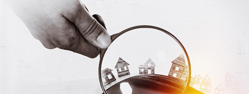 Paper house under a magnifying lens; Immobilienkauf